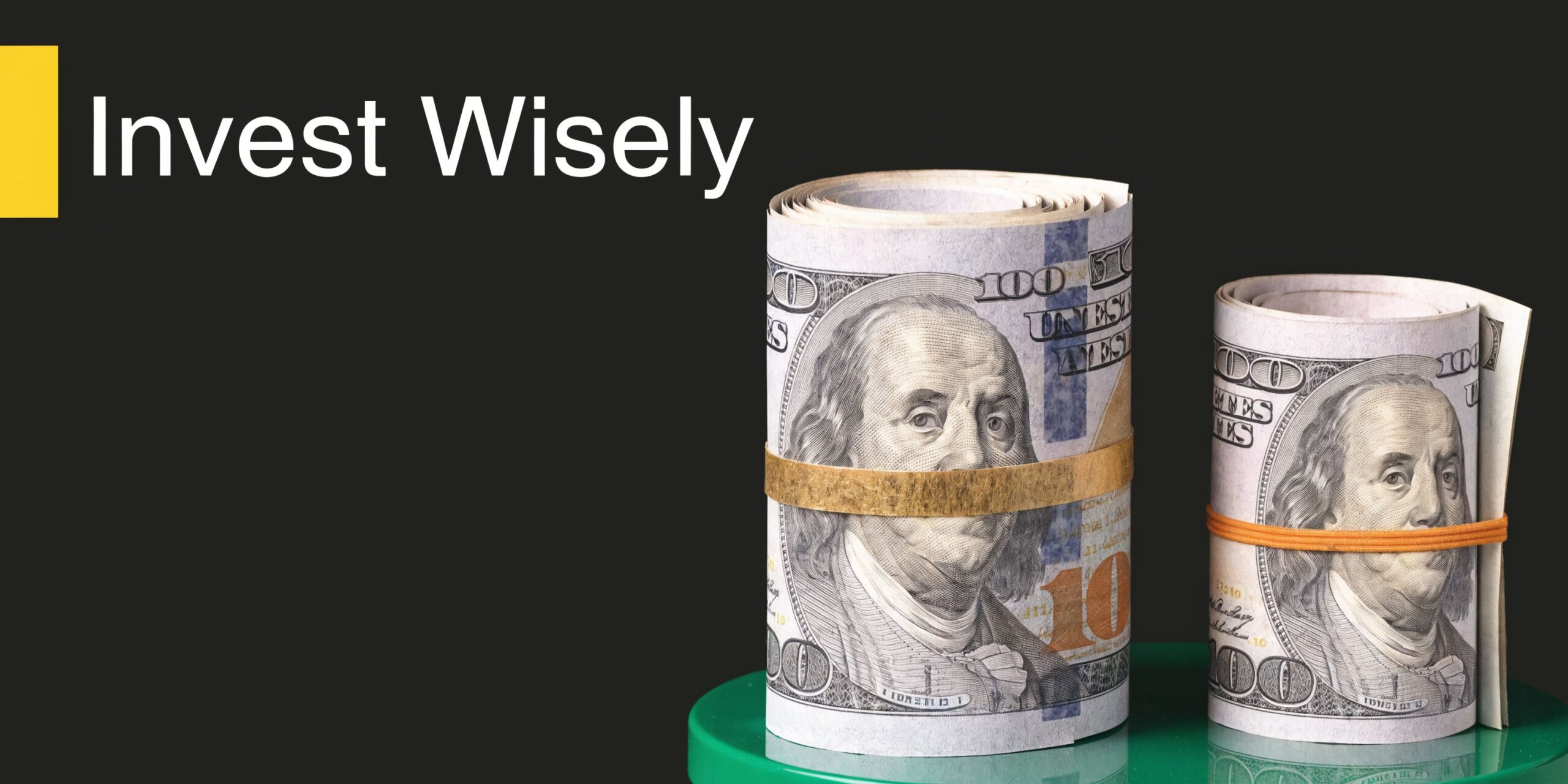 Two rolls of hundred dollar bills secured with rubber bands standing on a green surface, representing investments.