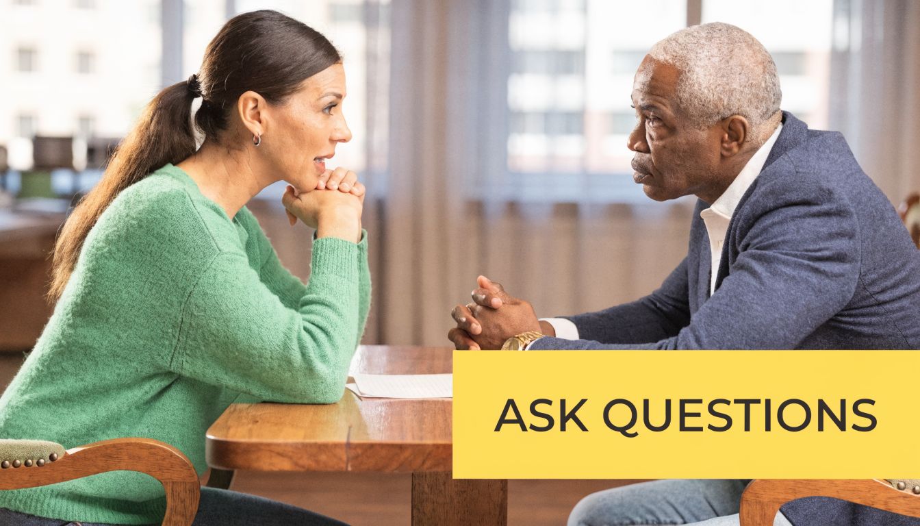A professional woman having a serious discussion with an older male attorney at an office table.