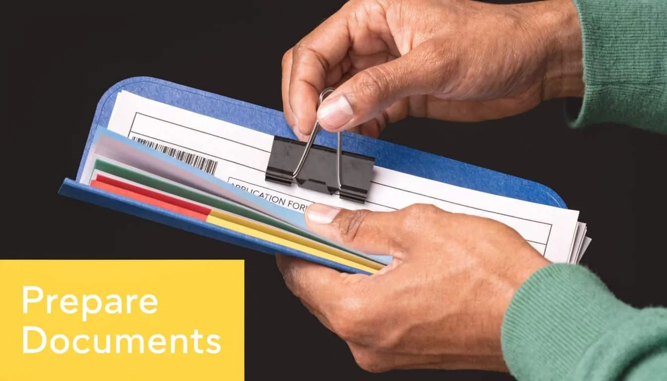A person organizing a blue folder filled with colorful documents using a black binder clip.