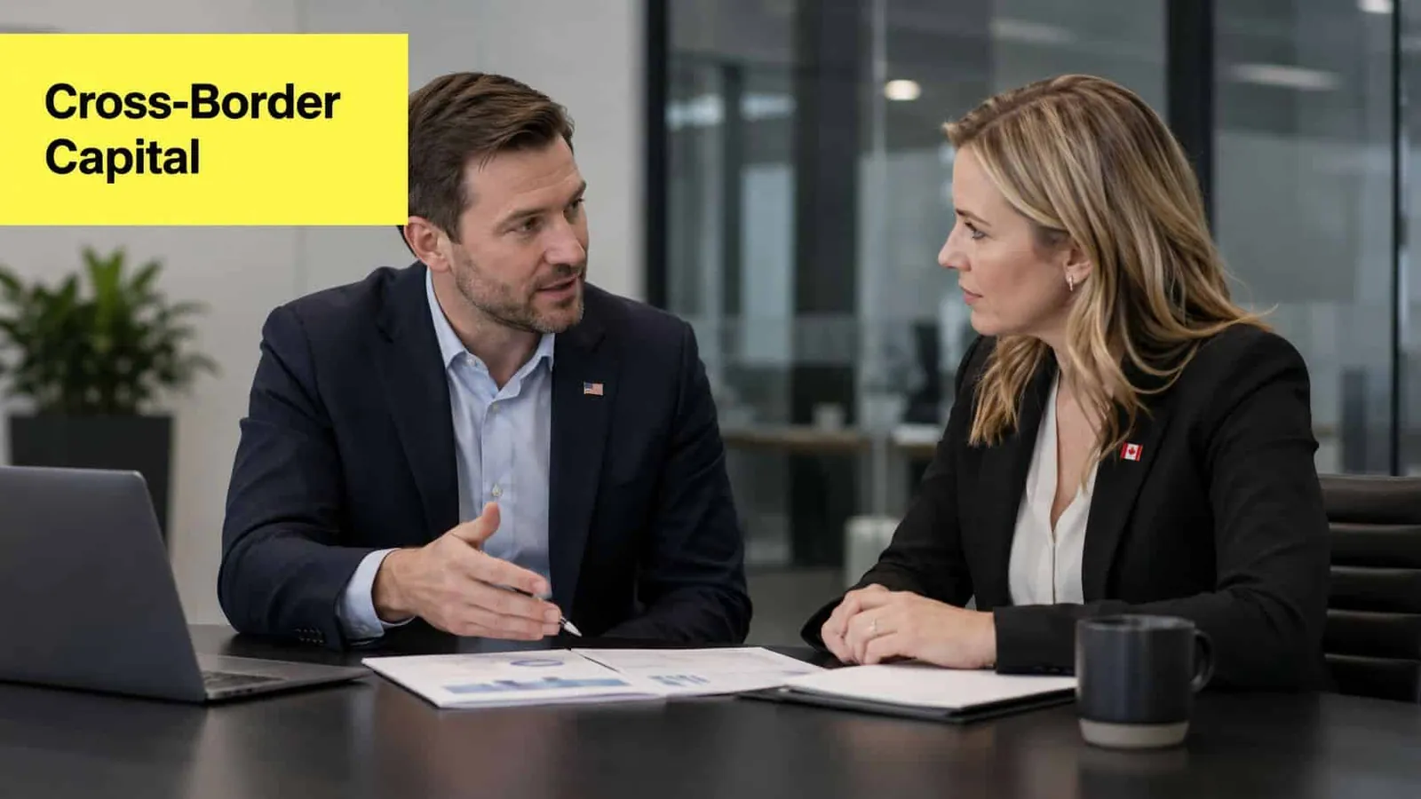 A professional man and woman in business attire discussing financial documents at an office conference table.